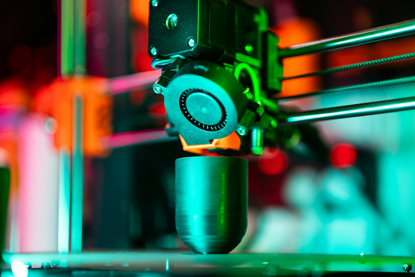 Ugello di stampante 3D che deposita materiale fuso su un oggetto metallico.